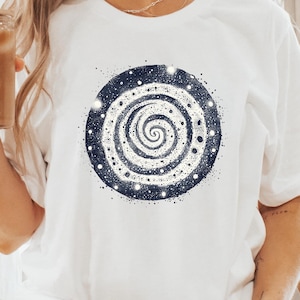 Könnte beinhalten: Weißes T-Shirt mit einem blauen und weißen Spiralmuster. Die Spirale ist von weißen Punkten auf einem dunkelblauen Hintergrund umgeben.