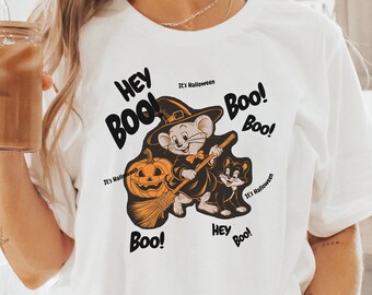 May include: White t-shirt with a black and orange Halloween graphic featuring a mouse and cat with the text "Hey Boo! It's Halloween! Boo! Boo! Boo! Hey Boo! Boo!"