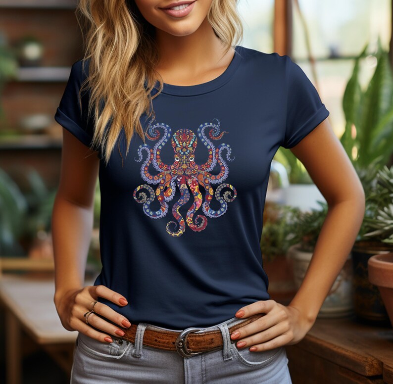 May include: Navy blue t-shirt featuring a colorful octopus design. The octopus is intricately detailed with red, orange, yellow, and blue patterns. The shirt has a classic crew neck and short sleeves.