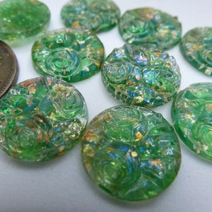 May include: Assortment of green glass buttons with a raised floral design and gold flecks. The buttons are round and have a slightly iridescent finish.