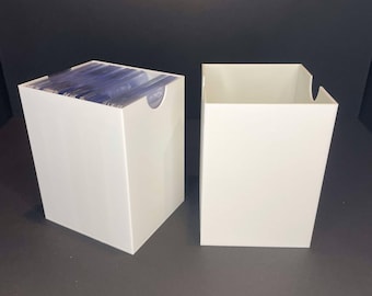May include: Two white cardboard boxes for storing trading cards. The box on the left is filled with cards, while the box on the right is empty.