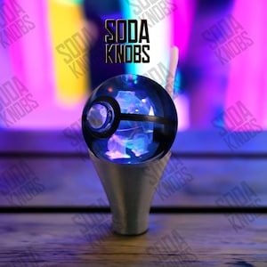 May include: A blue and black sphere-shaped soda knob with a silver base. The sphere has a black band and a circular design on the side. The text "SODA KNOBS" is visible above the knob.