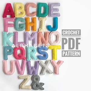 Może przedstawiać: Zestaw trzech ceramicznych kubków z nakrapianą, kremową glazurą. Każdy kubek ma inny ręcznie malowany wzór: niebiesko-zielony liść, żółty kwiat i czerwona jagoda. Kubki mają prosty, nowoczesny design.