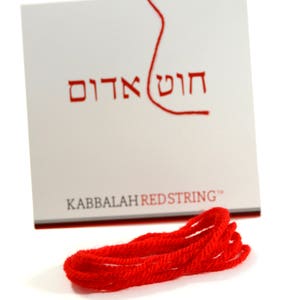 May include: A red string with the text "Kabbalah Redstring" on a white card with Hebrew text.