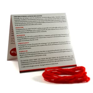 May include: Red string bracelet with a white background. The text on the card reads "The Red String Across Religions" and explains the meaning of the red string in Hinduism, Buddhism, Christianity, and Kabbalah.
