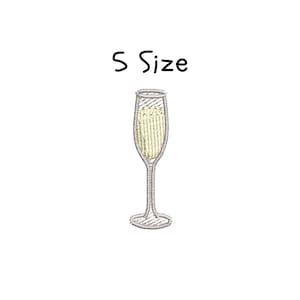 May include: An embroidered champagne flute filled with a bubbly, yellow liquid. The glass is outlined in silver thread, and the text "S Size" is above the glass. The design is on a white background.