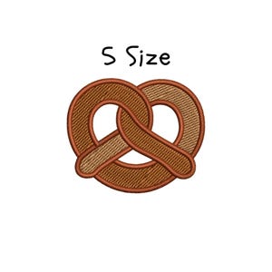 May include: An embroidered pretzel design in shades of brown and tan, with a darker brown outline. The text "S Size" is above the pretzel in black, handwritten-style lettering. The design is on a white background.