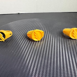 May include: A white ceramic mug with a black handle and the text "But First, Coffee" in a black, handwritten-style font. The mug is on a white surface.