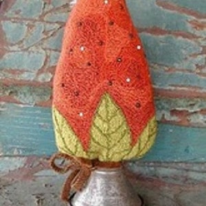 May include: A hand-stitched felt strawberry ornament with green leaves and a metal base. The strawberry is decorated with white beads.