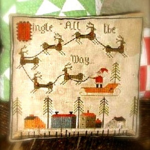 May include: A cross-stitch sampler with a Christmas scene featuring Santa Claus in a red suit riding in a sleigh pulled by reindeer. The text "Jingle All The Way" is stitched in red and black thread. The scene is set against a backdrop of a snowy village with houses and trees.