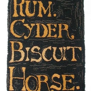 May include: A black and orange rug with the words "RUM. CYDER. BISCUIT HORSE." in a vintage font.