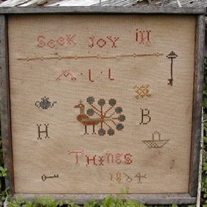 May include: A vintage needlepoint sampler with the text "Seek Joy in All Things 1807" and a colorful peacock design. The sampler is framed in a rustic wooden frame.
