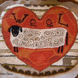 May include: A needlepoint pillow with a red heart and a white sheep in the center. The heart has the word "Wool" embroidered on it. The pillow is surrounded by a brown and white striped border.