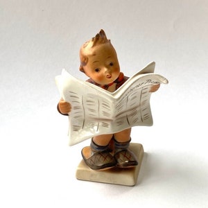 Hummel boy reading newspaper shop