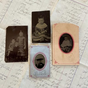 May include: Four vintage photographs of children. The photos are in black and white and are framed in paper with a decorative border. The photos are all of different sizes and shapes. The photos are all of children in different poses. The photos are all in good condition.