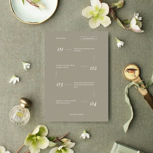 May include: A flat lay featuring a planning system with a neutral color palette. The image includes a decorative plate, flowers, a perfume bottle, a decorative knife, and a book. The text on the card reads "Elevate Planning" and "Task Management".