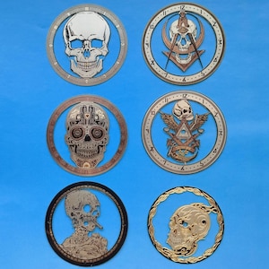 May include: Six different circular metal wall clocks with skull designs. Each clock has a different design, including a skull with a Masonic symbol, a skull with a Day of the Dead design, and a skull with a skeleton body.