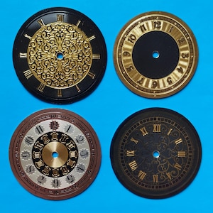 May include: Four clock faces with various designs. Two feature Roman numerals, one has Arabic numerals, and one has a decorative pattern. The colours include black, gold, brown, and silver. Each face has a central hole.