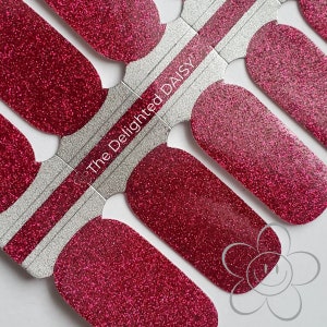 May include: A sheet of red glitter nail polish wraps with the text "The Delighted Daisy" printed on the sheet.