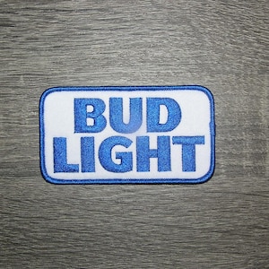 Peut inclure: Écusson brodé blanc avec inscription bleue "Bud Light".
