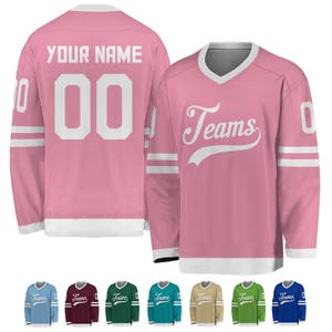 May include: Pink hockey jersey with white accents. The jersey features the word "Teams" in a script font on the front and the number "00" on the back. The sleeves have white stripes. Additional jersey colors are shown at the bottom.