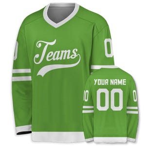 May include: A green hockey jersey with white accents, featuring the word "Teams" in a script font on the front. The jersey has white stripes on the sleeves and the number "0" on the sleeves and back. The back also has the text "YOUR NAME" above the number "00".