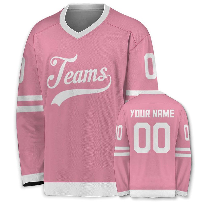 May include: Pink hockey jersey with white accents, a V-neck, and long sleeves. The front features the word "Teams" in a script font. The back displays "YOUR NAME" above the number "00".