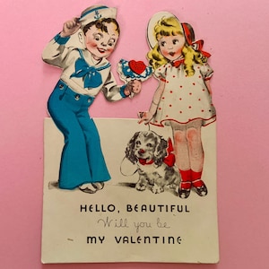 May include: Vintage Valentine's Day card featuring a sailor boy and a girl in a polka dot dress. The card includes a dog with a red bow and the text "Hello, Beautiful, Will you be my Valentine?" on a pink background.