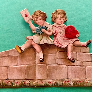 Cartão vintage de dia dos namorados, duas meninas sentadas em uma parede de pedra segurando cartões de dia dos namorados