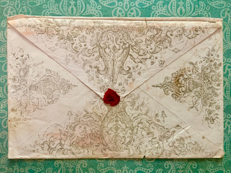 May include: A vintage envelope with a decorative design and a red wax seal.