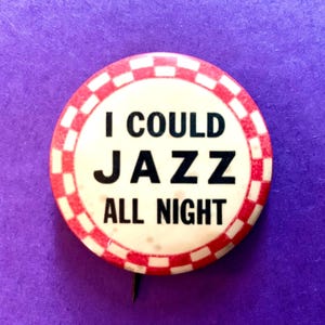 May include: A round button with the text "I COULD JAZZ ALL NIGHT" in black letters. The button has a white center with a red and white checkered border and a pin on the back. The background is purple.