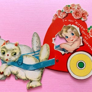 Vintage mechanische Valentijnsdagkaart 2 witte katten trekkend meisje rijdt in een hart op wielen
