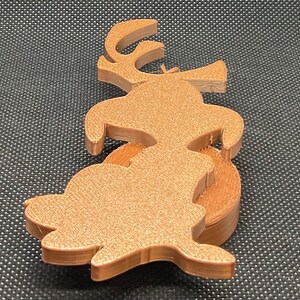 May include: A wooden reindeer ornament with a brown glitter finish. The reindeer is standing on a round wooden base.