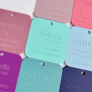 May include: A collection of colorful, square-shaped tags with rounded corners. Each tag features a name and contact information, including a phone number and email address. The tags are in various colors, including pink, blue, and purple.