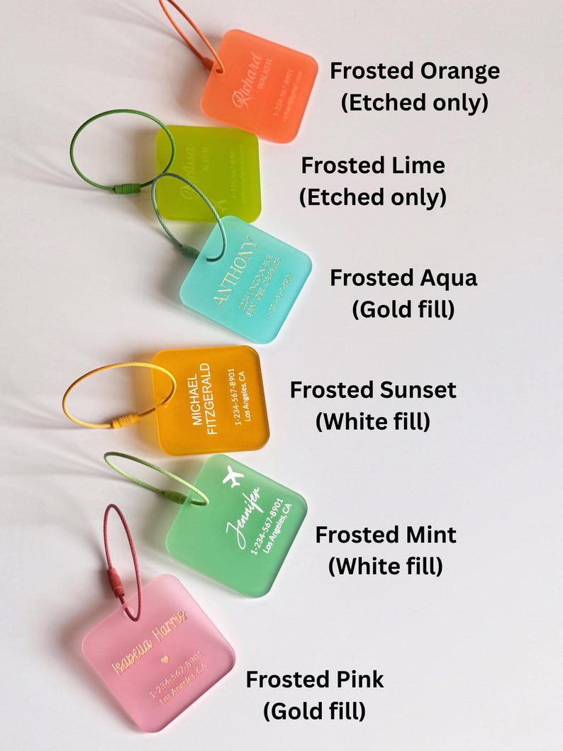 May include: A collection of frosted luggage tags in various colors, including orange, lime, aqua, sunset, mint, and pink. Each tag features etched or filled text with names and contact information. The tags are square with rounded corners and attached to metal loops.