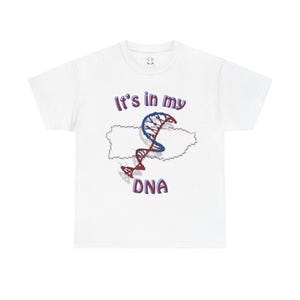 Puede incluir: Camiseta blanca con un diseño de cadena de ADN azul y rojo en forma de Puerto Rico. El texto "It's in my DNA" está impreso en la camiseta.