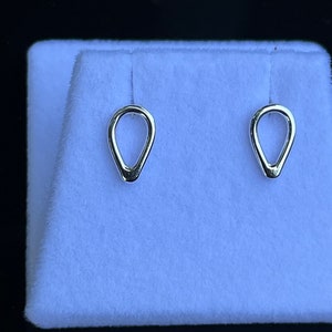 Puede incluir: Un par de pendientes de plata en forma de lágrima con un acabado liso y pulido.