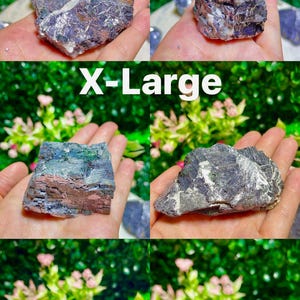 Puede incluir: Cinco cristales de galena de diferentes tama&ntilde;os, que van desde peque&ntilde;os hasta extra grandes. Los cristales son de color gris oscuro con un brillo met&aacute;lico. Tienen una superficie rugosa e irregular. Los cristales se muestran en una mano.