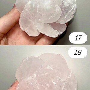 May include: Two carved stone rose sculptures. The top rose is white, and the bottom rose is pink. The petals are detailed with carved lines. The numbers "17" and "18" are printed on the image.
