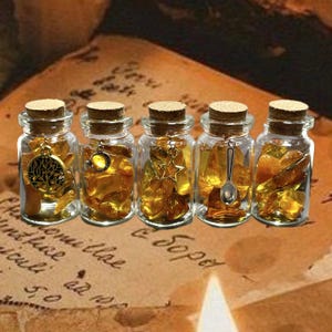 May include: Five small glass jars with cork stoppers, filled with amber-colored stones. Each jar has a different charm hanging from the top: a tree, a moon, a star, a spoon, and a stone. The jars are arranged on a vintage paper background.