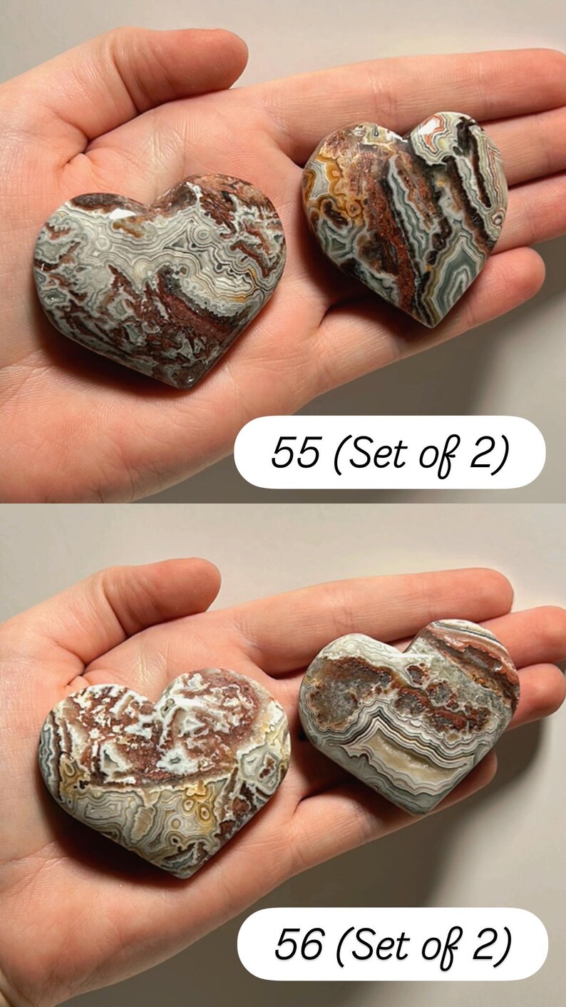 May include: Two heart-shaped stones with a marbled pattern in shades of brown, white, and gray. The stones are held in a hand. The text "55 (Set of 2)" and "56 (Set of 2)" is visible.