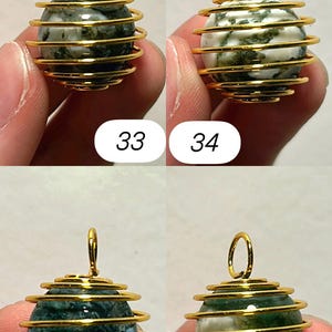 May include: Four gemstone pendants with gold-colored wire cage designs. The gemstones are spherical, with green and white patterns. Each pendant has a small loop at the top for hanging. Numbers 33, 34, 35, and 36 are printed below each pendant.