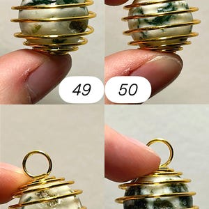 May include: A gold-colored wire-wrapped pendant with a round, off-white stone featuring green inclusions. The pendant has a loop at the top for hanging. Numbers 49, 50, 51, and 52 are visible in the image.