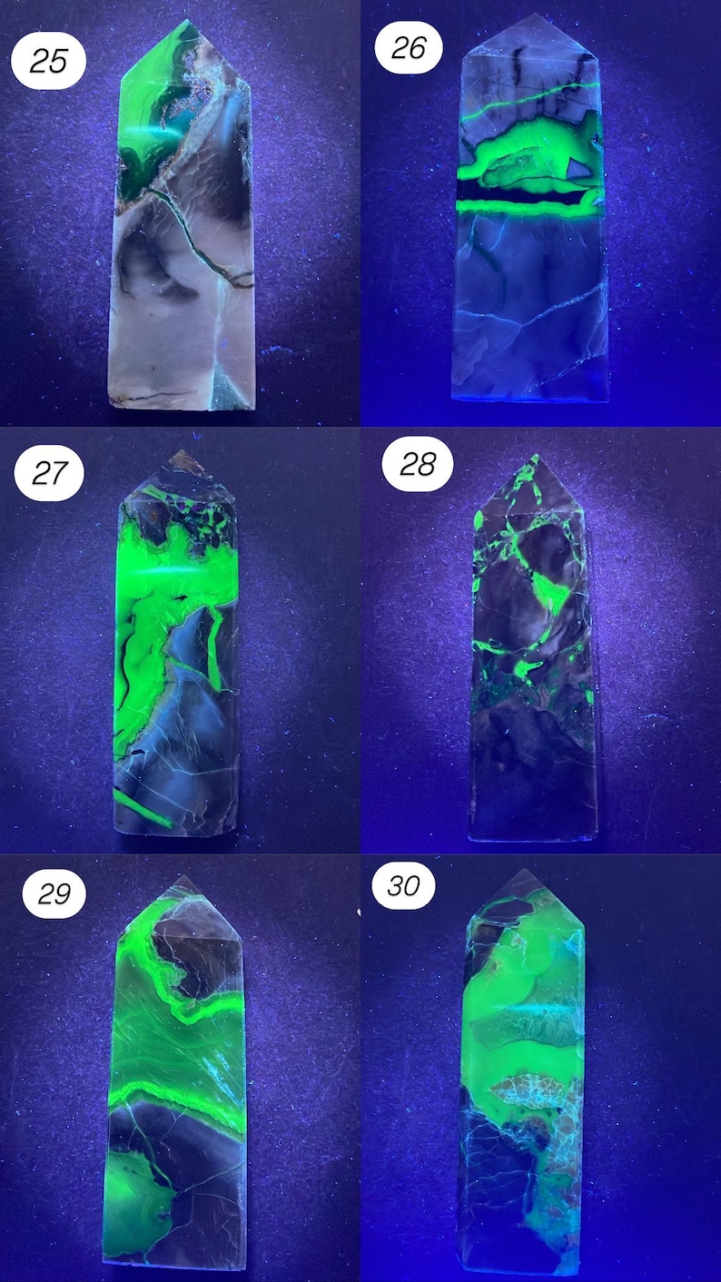 K&ouml;nnte beinhalten: Eine Sammlung von sechs fluoreszierenden Mineralproben, jeweils ein rechteckiges Prisma mit spitzer Spitze. Die Mineralien zeigen unter ultraviolettem Licht eine Vielzahl von Farben, darunter Gr&uuml;n, Schwarz und Grau. Die Proben sind von 25 bis 30 nummeriert.