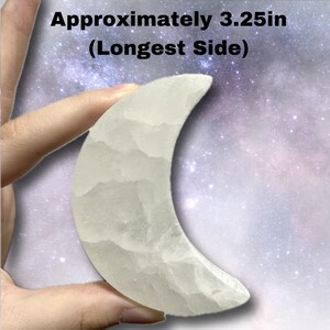 K&ouml;nnte beinhalten: Ein transluzenter, halbmondf&ouml;rmiger Kristall. Die l&auml;ngste Seite misst ca. 8,26 cm. Der Kristall hat eine strukturierte Oberfl&auml;che und wird vor einem Sternenhintergrund gehalten.