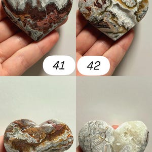 May include: Four heart-shaped stones with unique patterns and colors. The stones are held in a hand and numbered 41, 42, 43, and 44. The stones have a variety of colors, including red, brown, white, and gray. The stones are likely decorative items.