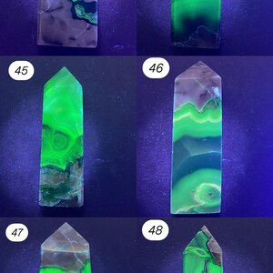 K&ouml;nnte beinhalten: Sammlung von sechs polierten Edelstein-Obelisken. Jeder Obelisk hat eine andere Farbe, darunter Gr&uuml;n, Blau und Lila. Die Edelsteine haben eine durchscheinende Qualit&auml;t mit sichtbaren Mustern und Einschl&uuml;ssen. Die Obelisken werden vor einem dunklen Hintergrund ausgestellt.