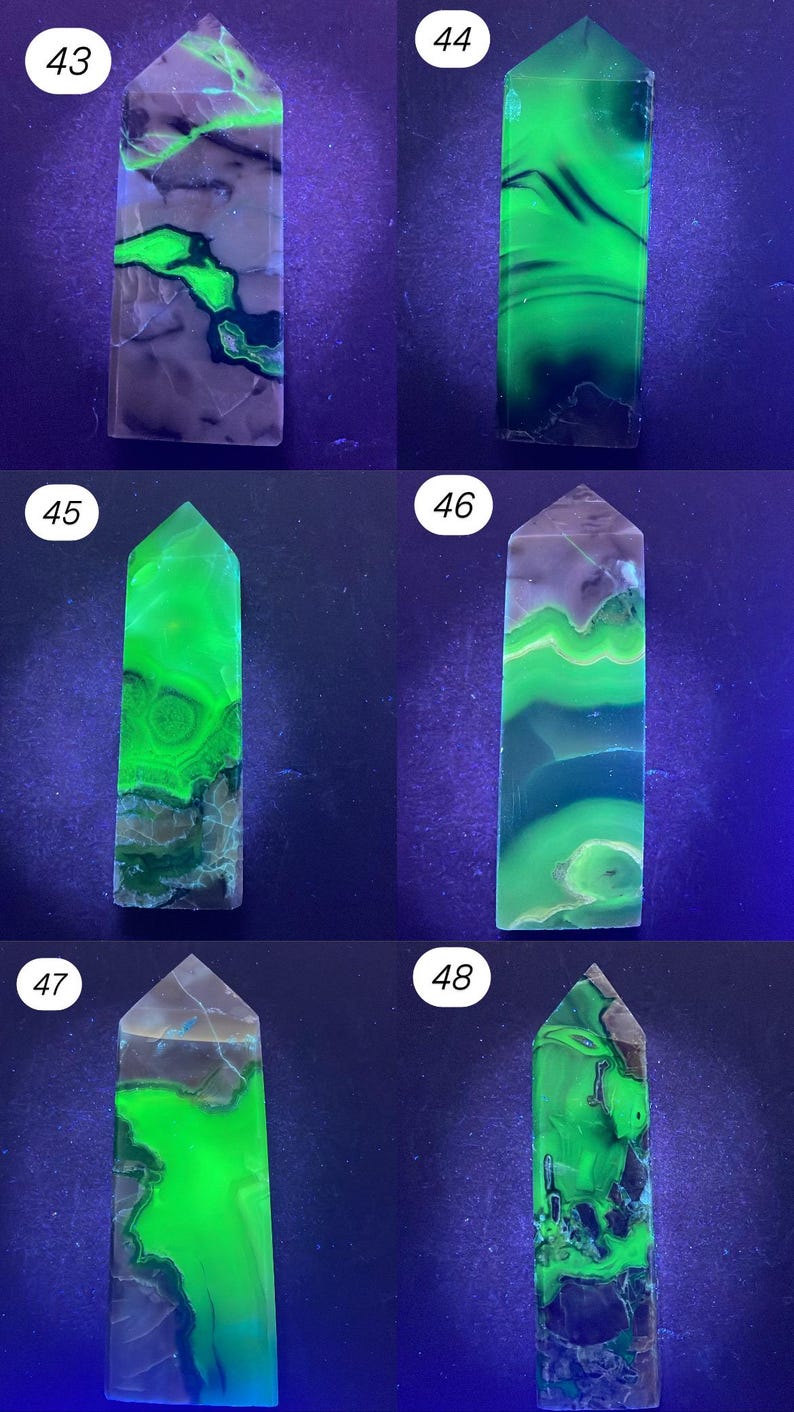 K&ouml;nnte beinhalten: Sammlung von sechs polierten Edelstein-Obelisken. Jeder Obelisk hat eine andere Farbe, darunter Gr&uuml;n, Blau und Lila. Die Edelsteine haben eine durchscheinende Qualit&auml;t mit sichtbaren Mustern und Einschl&uuml;ssen. Die Obelisken werden vor einem dunklen Hintergrund ausgestellt.