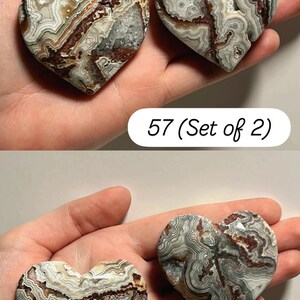 May include: Two heart-shaped stones with intricate patterns of gray, brown, and white. The stones are held in a hand. The text "57 (Set of 2)" and "58 (Set of 2)" are visible.