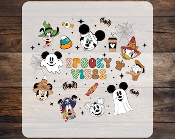 May include: A DTF transfer sheet featuring the text SPOOKY VIBES in colourful striped letters surrounded by cartoon characters in Halloween costumes, including ghosts, a mummy, a pirate, a pumpkin, sweets, spiderwebs, and bats on a white background.